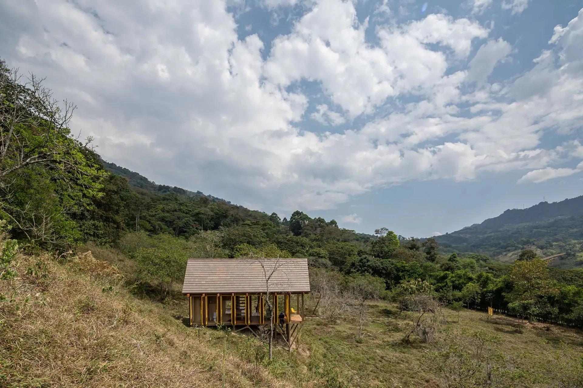 Habitación del refugio integrada de forma abierta al baño con acabados de madera nativa.